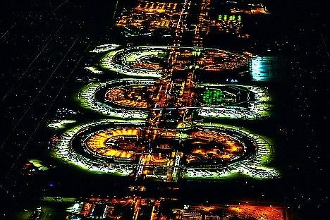 Luxury black SUV transfers at DFW Airport – nighttime aerial view of Dallas Fort Worth International Airport with illuminated terminals and runways.